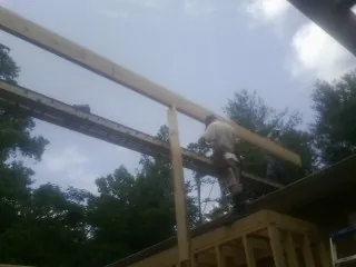 Carpenter setting a ridge beam over a new addition frame — Ice Dam Removal by Roofing Brothers in Porter Corners