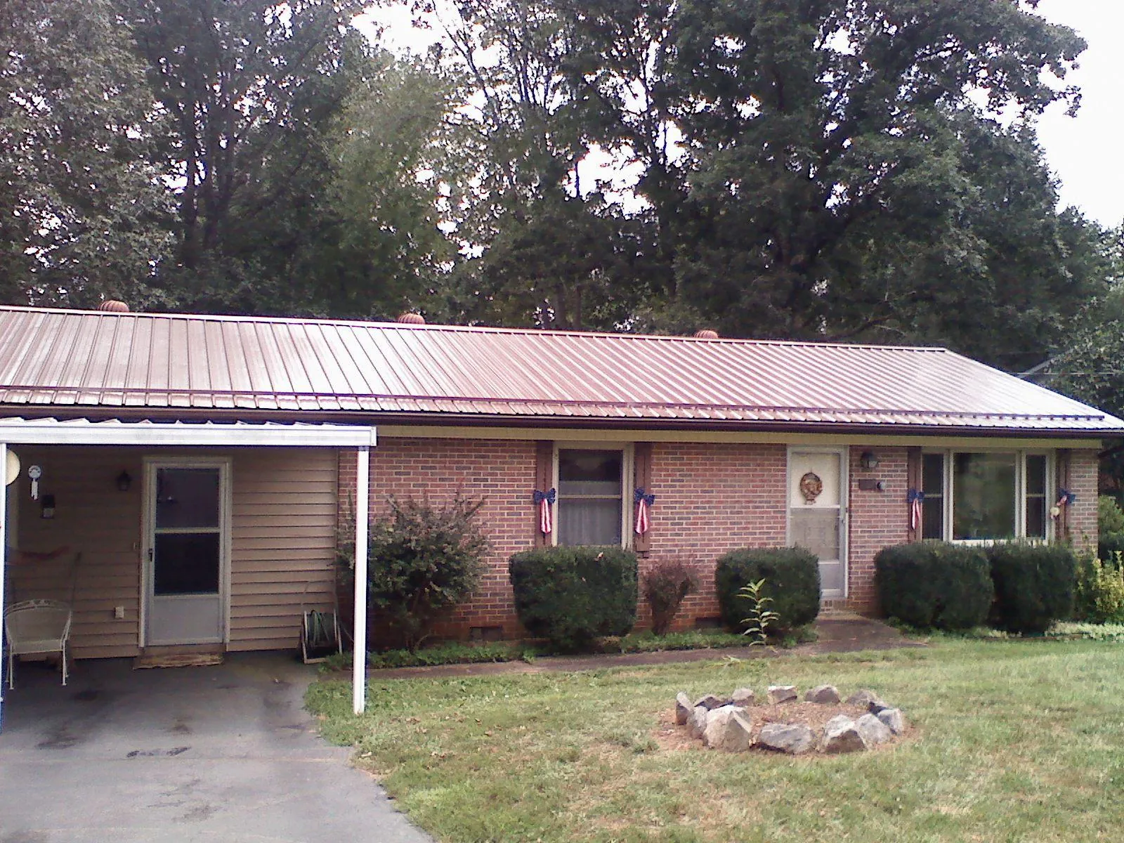 Bronze metal roof and carport on a brick ranch home — Roof Repair work by our crew in Porter Corners